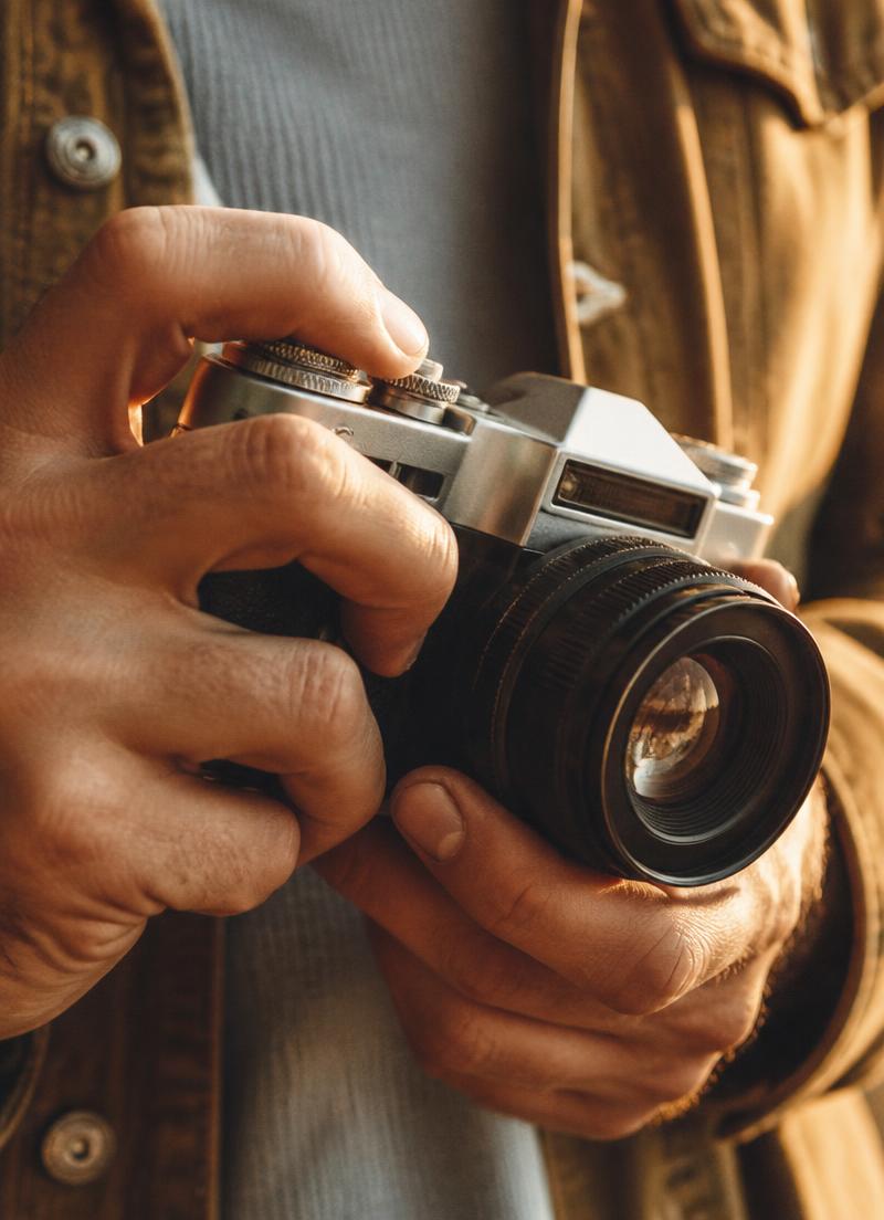 Mãos segurando uma câmera fotográfica analógica
